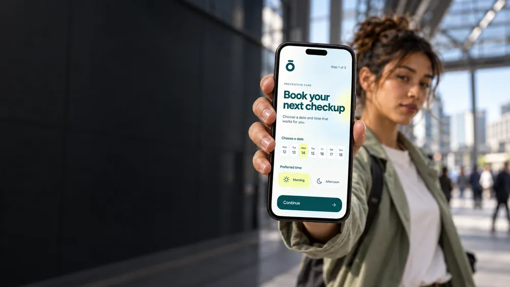 'Book your next checkup' 메시지가 표시된 헬스케어 앱 화면을 스마트폰으로 보여 주는 사람입니다. 앱에는 날짜 선택 달력과 희망 시간대를 오전 또는 오후로 선택하는 항목이 표시되어 있습니다.