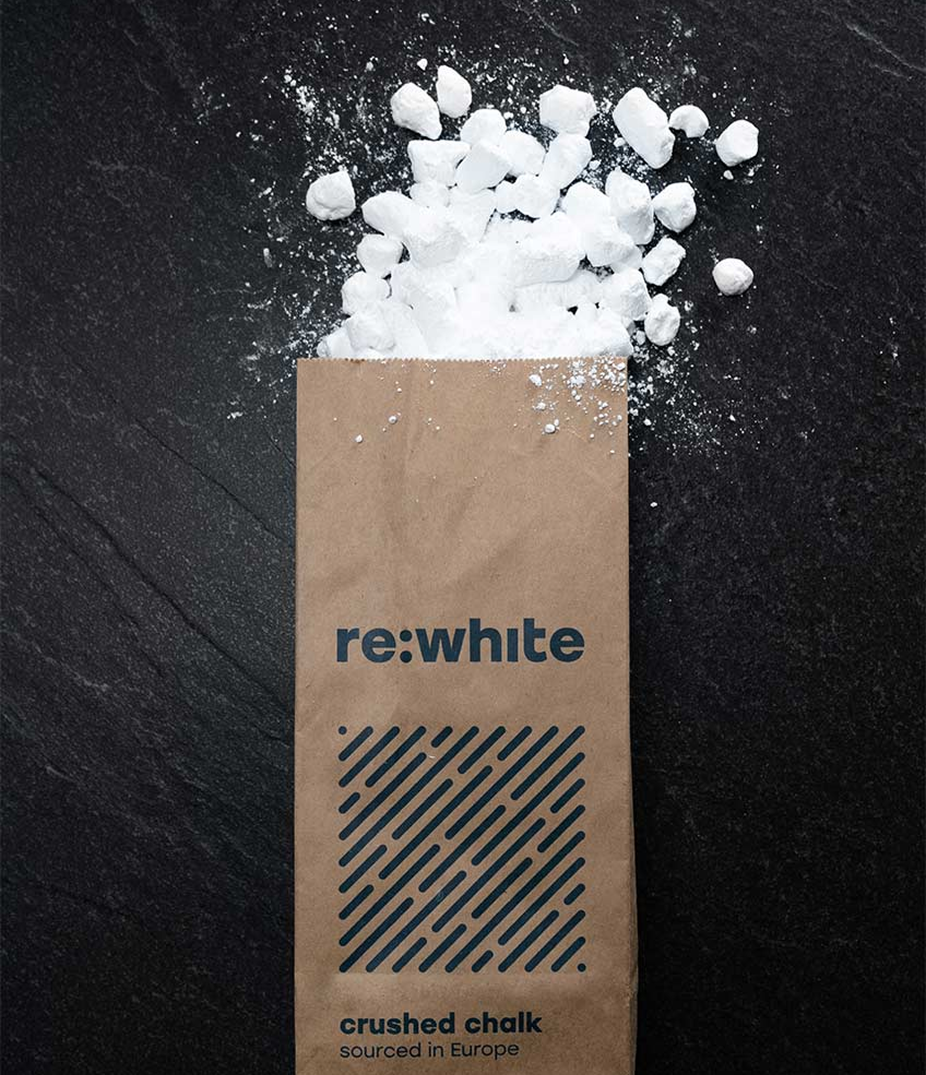 Bag of crushed chalk spilling on a dark surface.