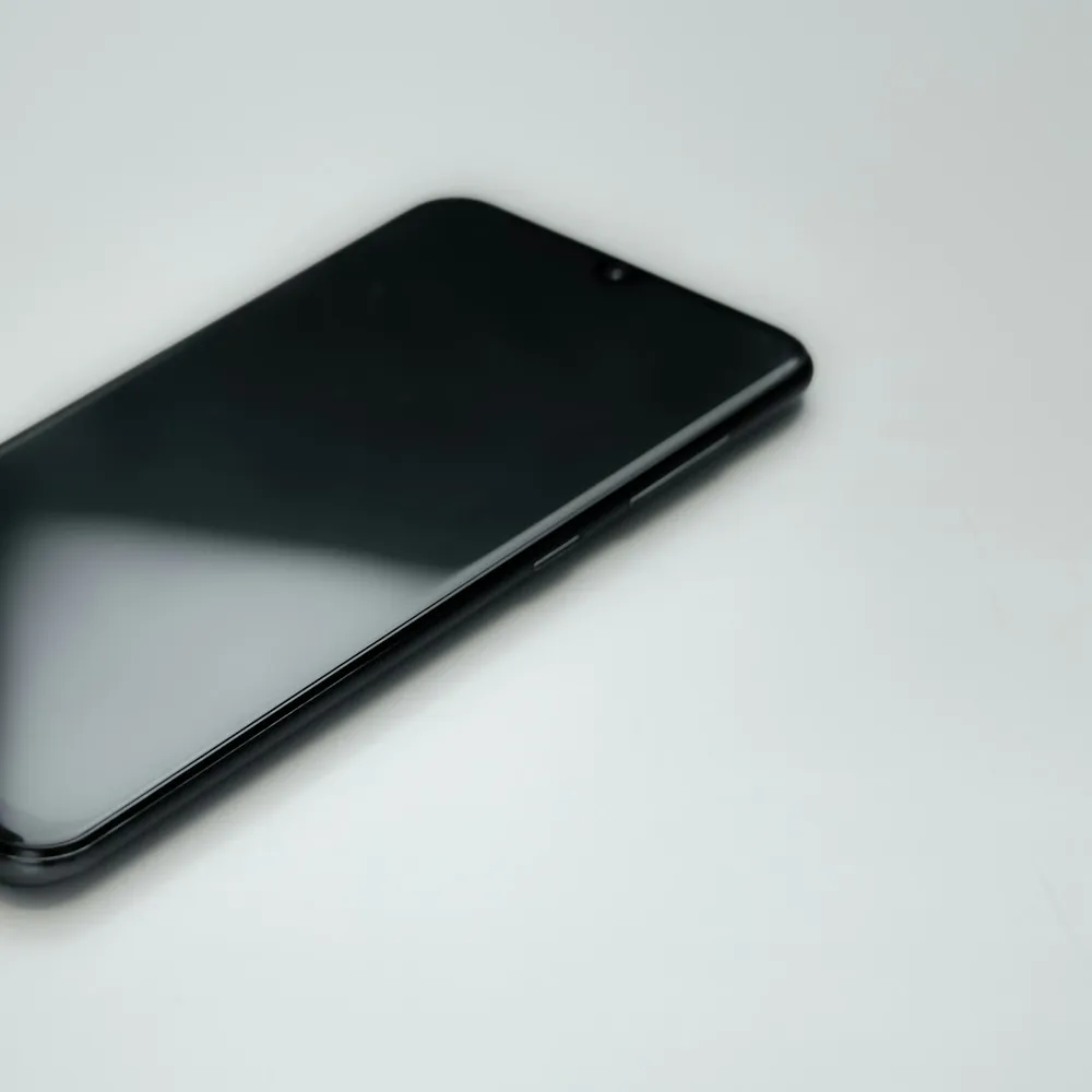 Black smartphone on a white surface.