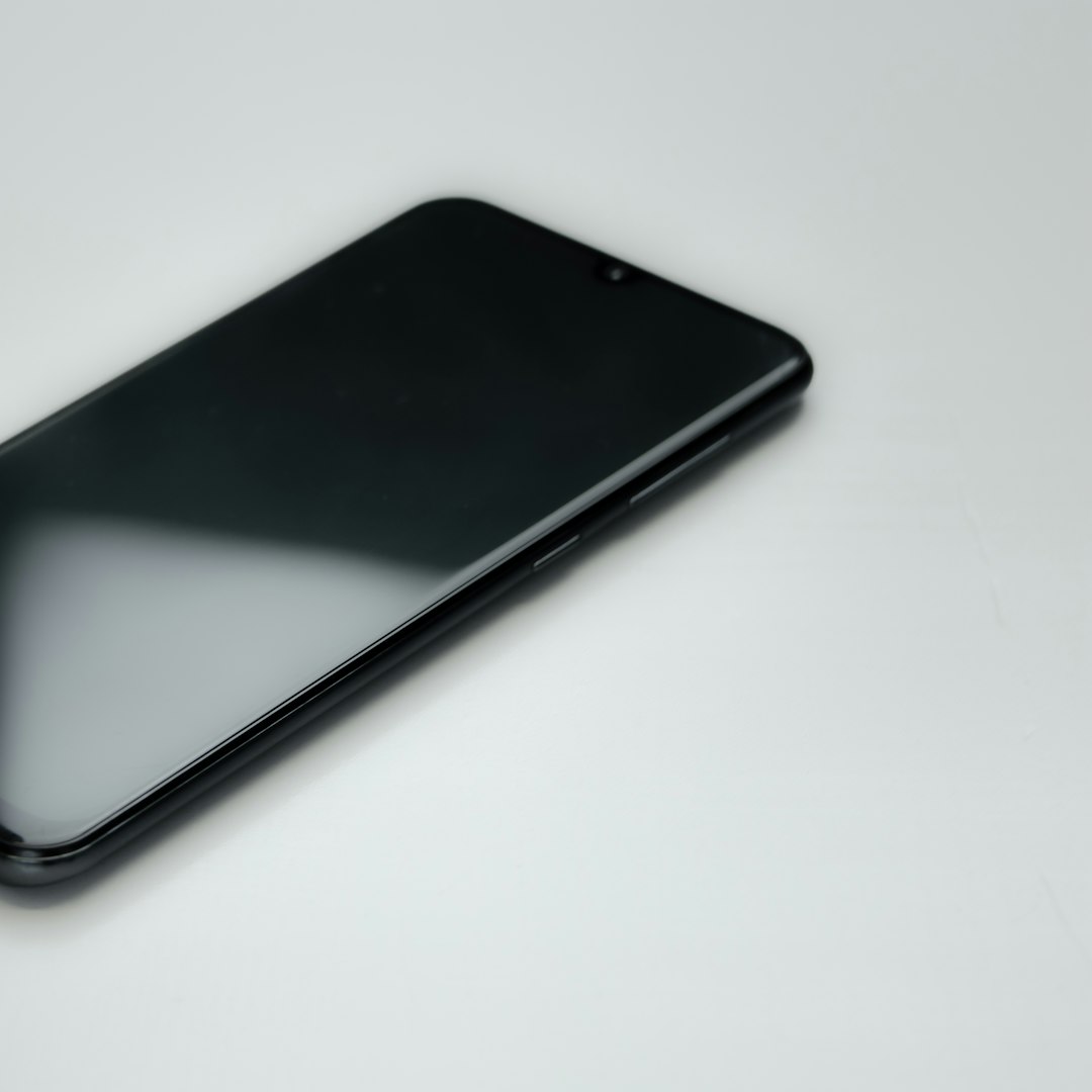Black smartphone on a white surface.