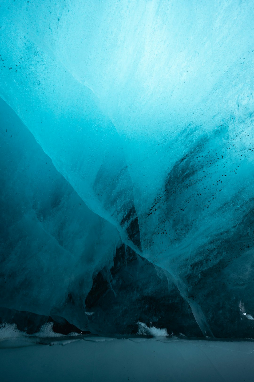 Blue ice cave interior with textured walls.
