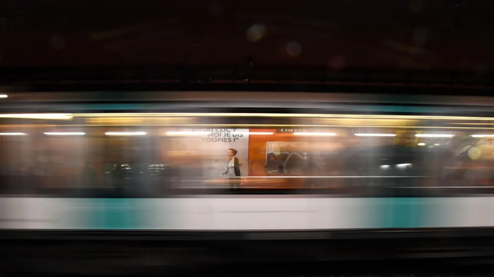 Blurred motion of a subway train passing by a station.