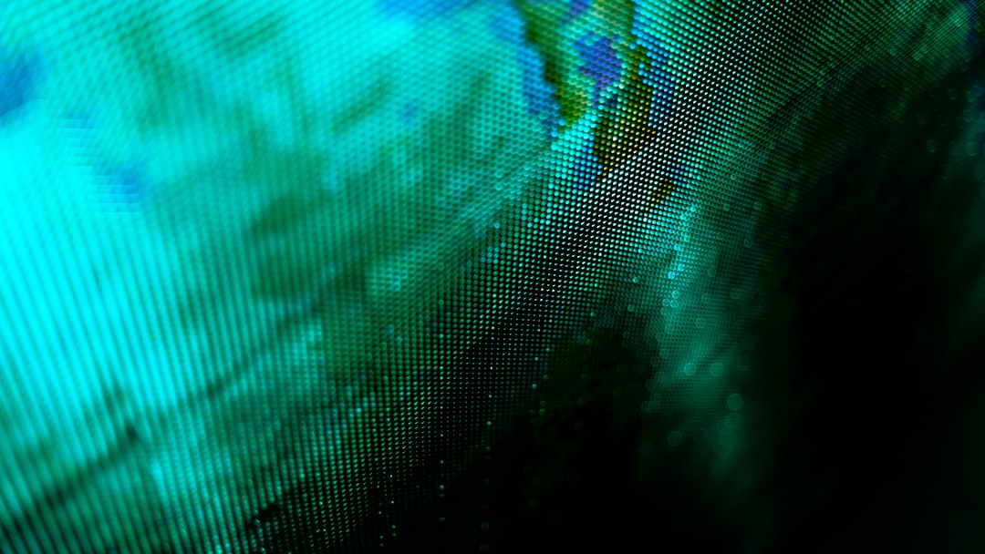 Close-up of a digital screen with pixelated patterns in green and blue hues.