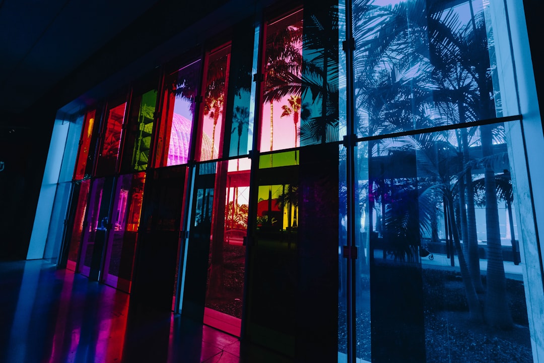 Colorful glass panels reflecting palm trees.