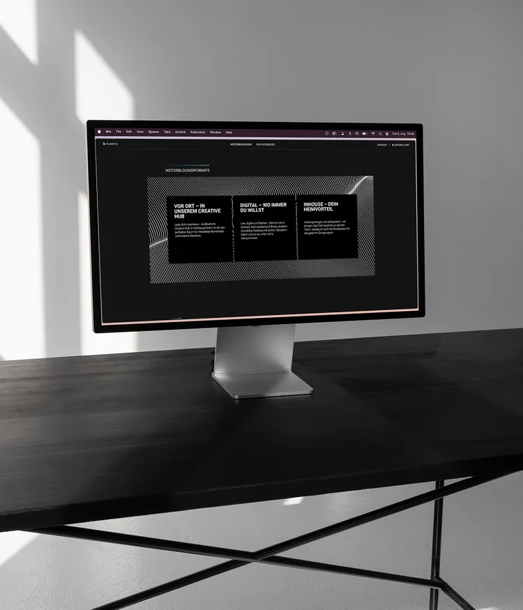 Computer monitor on a dark desk displaying a website.