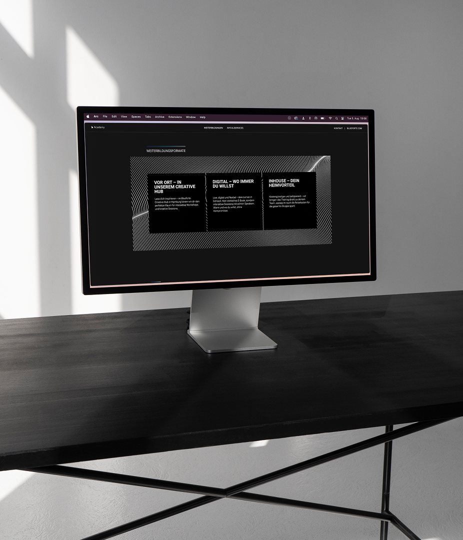 Computer monitor on a dark desk displaying a website.