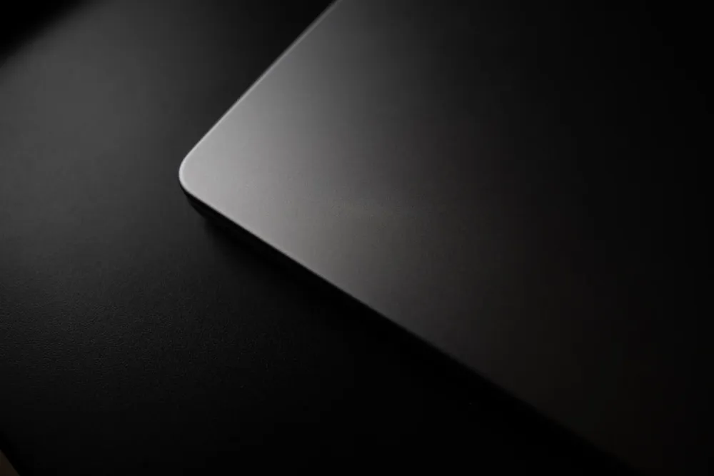 Corner of a closed laptop on a dark surface.