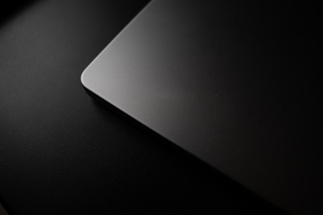 Corner of a closed laptop on a dark surface.
