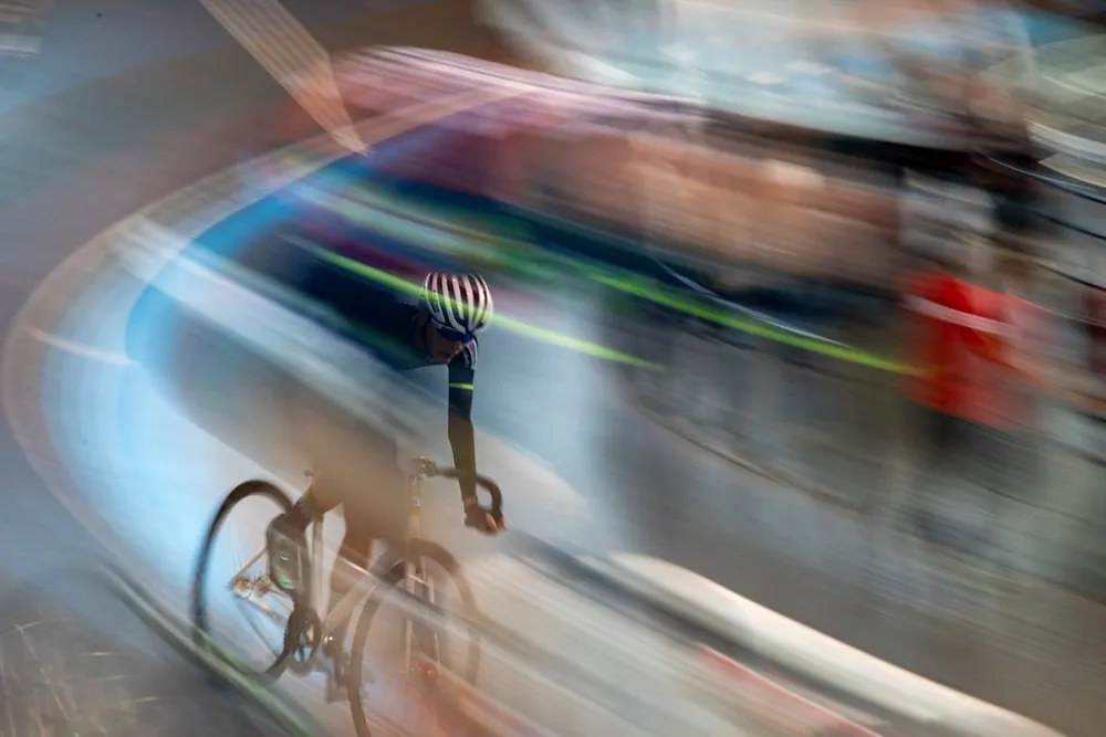 Cyclist racing on a track with motion blur.