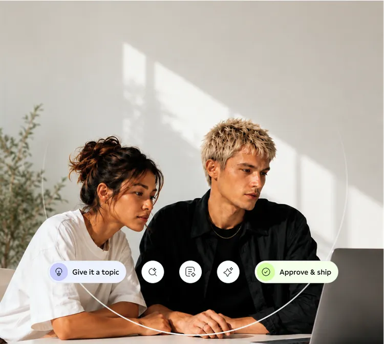 A man and a woman are intently looking at a laptop screen. In front of them, there are user interface elements with text such as "Give it a topic" and "Approve & ship". The scene is in a bright room with plants in the background.