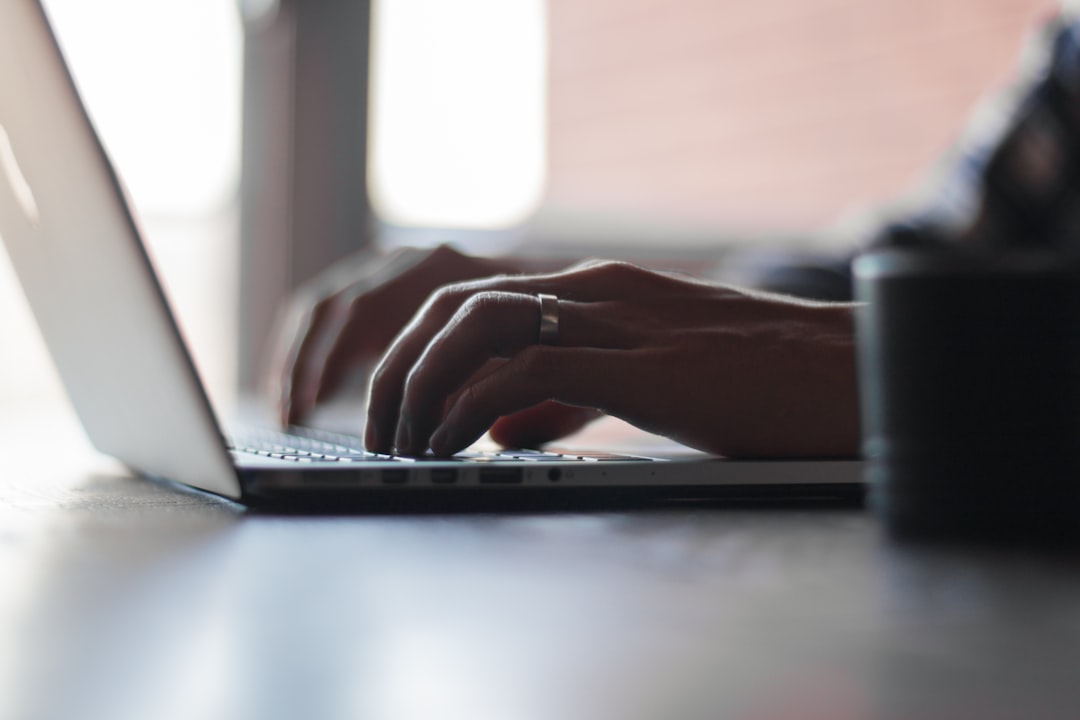 Hands typing on a laptop keyboard.