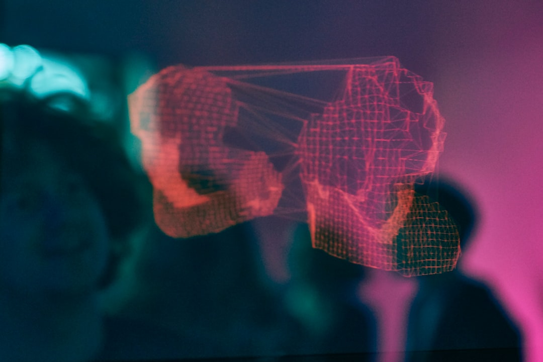 Holographic red wireframe projection in a dark room.