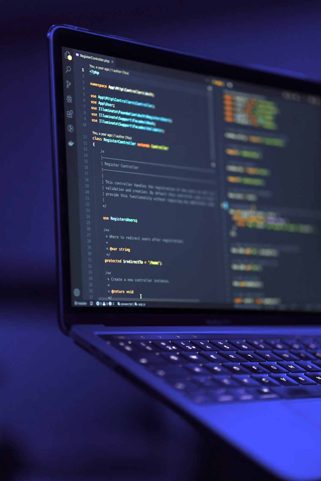 Laptop displaying code on screen in a dimly lit room.