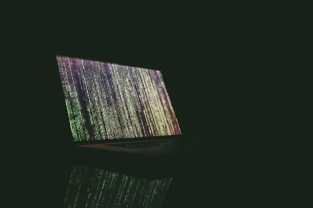 Bærbar computer, der viser lodrette kodelinjer i en mørk indstilling.