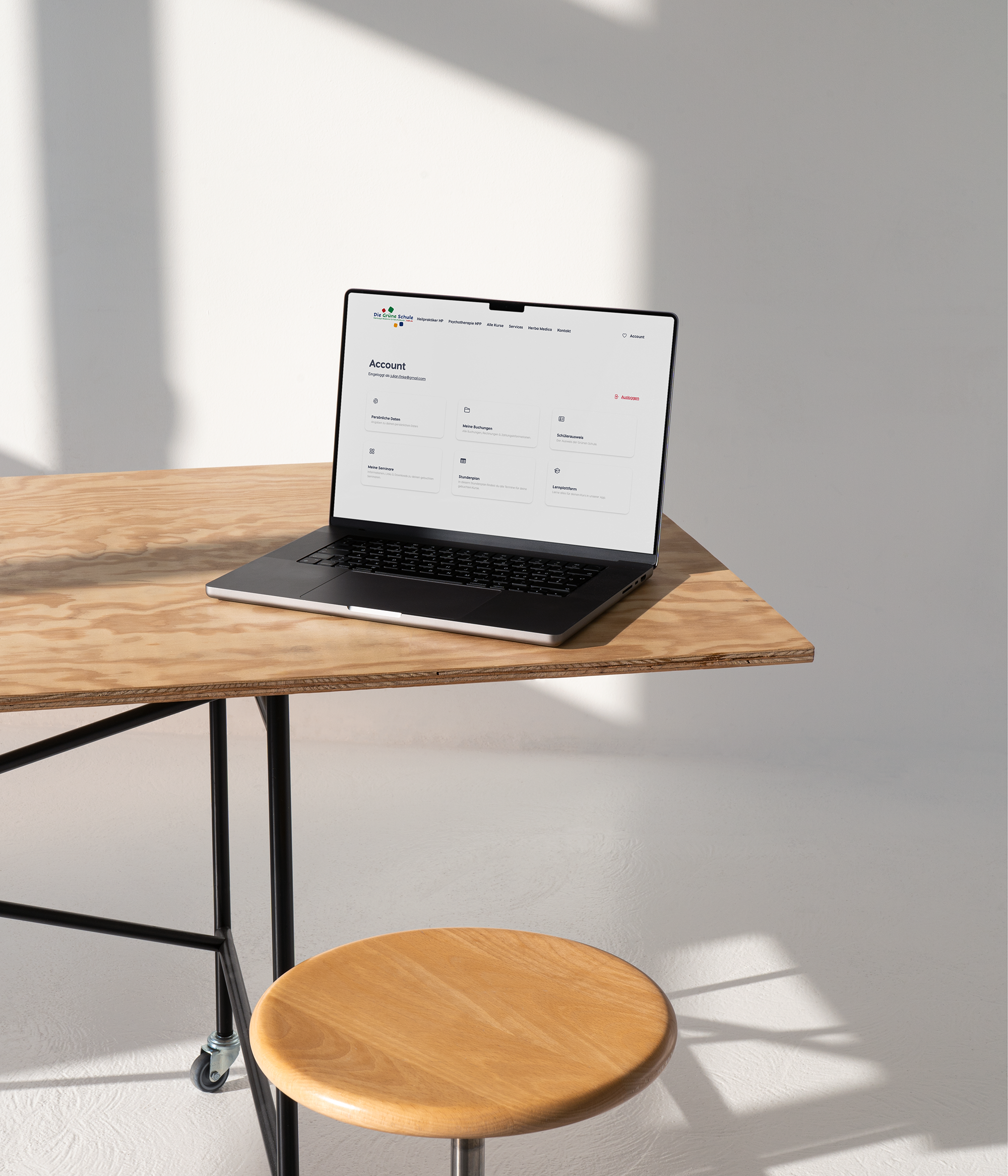 Laptop on a wooden table in a bright room.