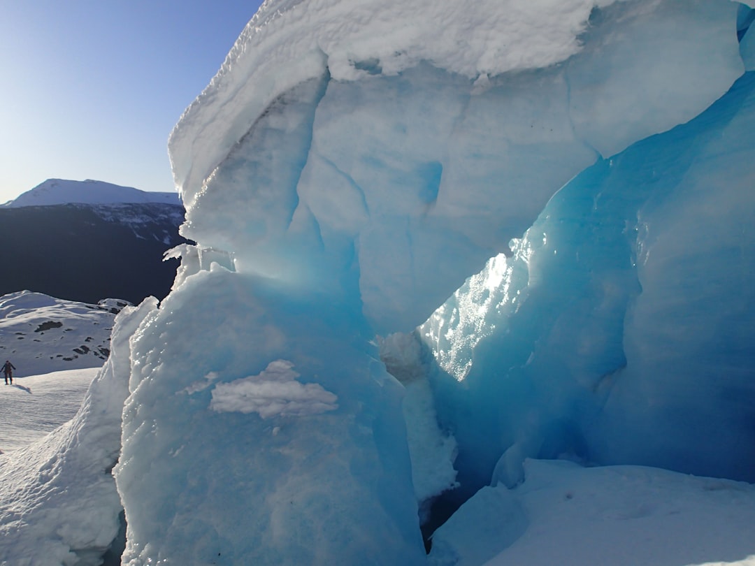 Large blue ice formation in a snowy landscape.