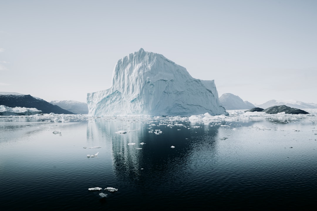 Large iceberg floating in calm water.