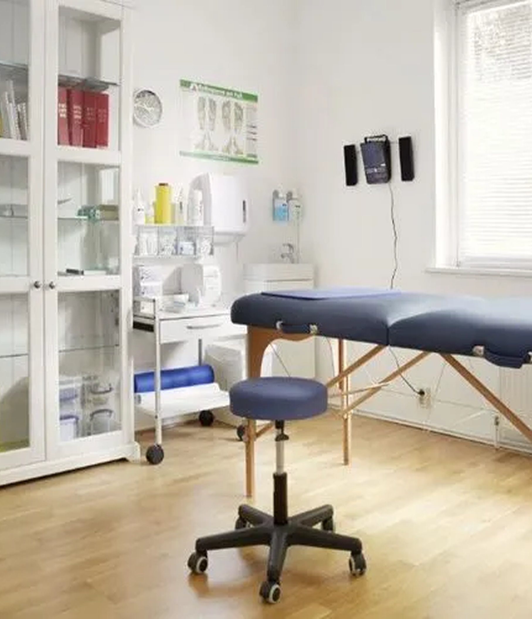 Medical examination room with a treatment table and stool.