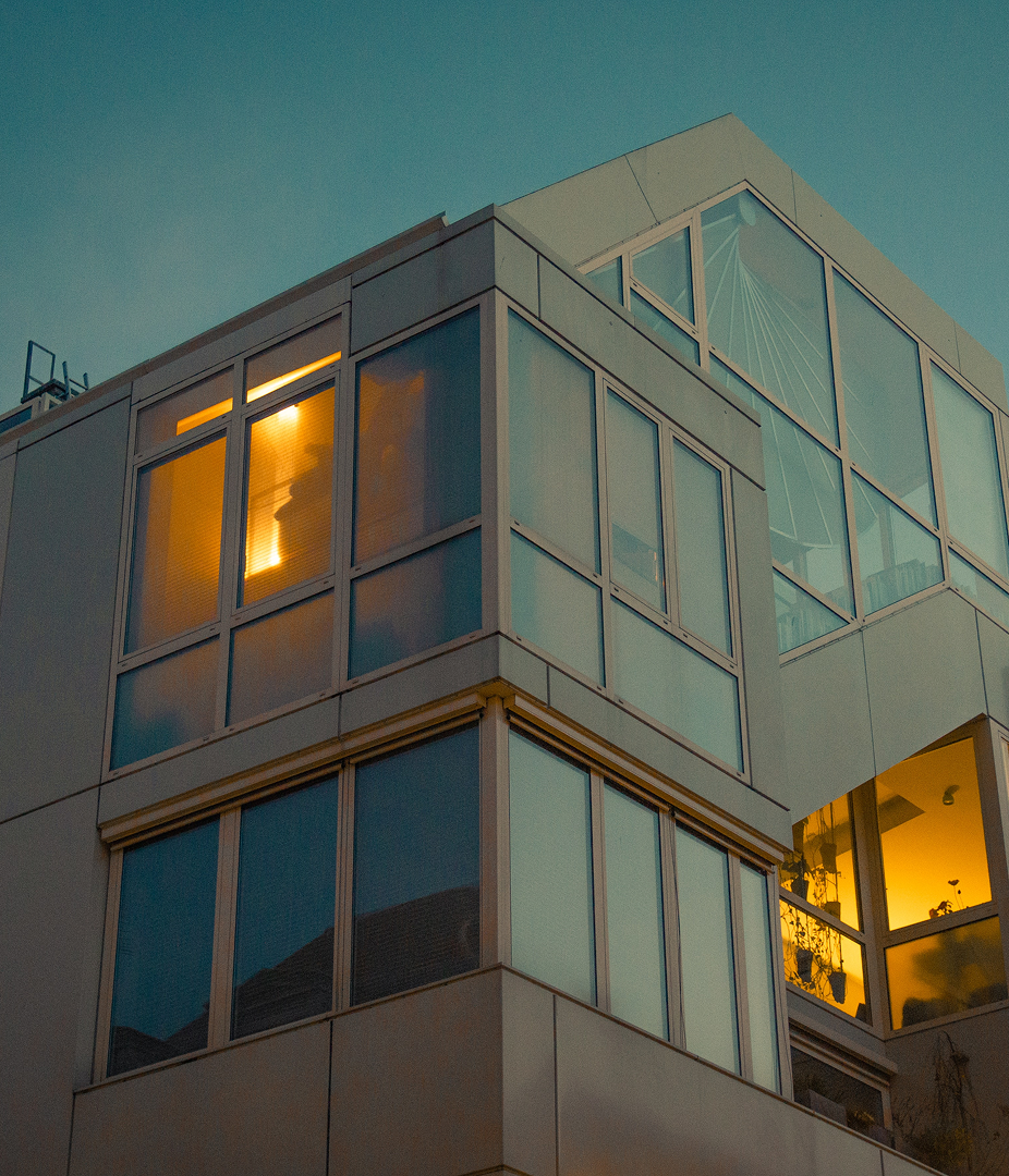 Modern building with illuminated windows at dusk.