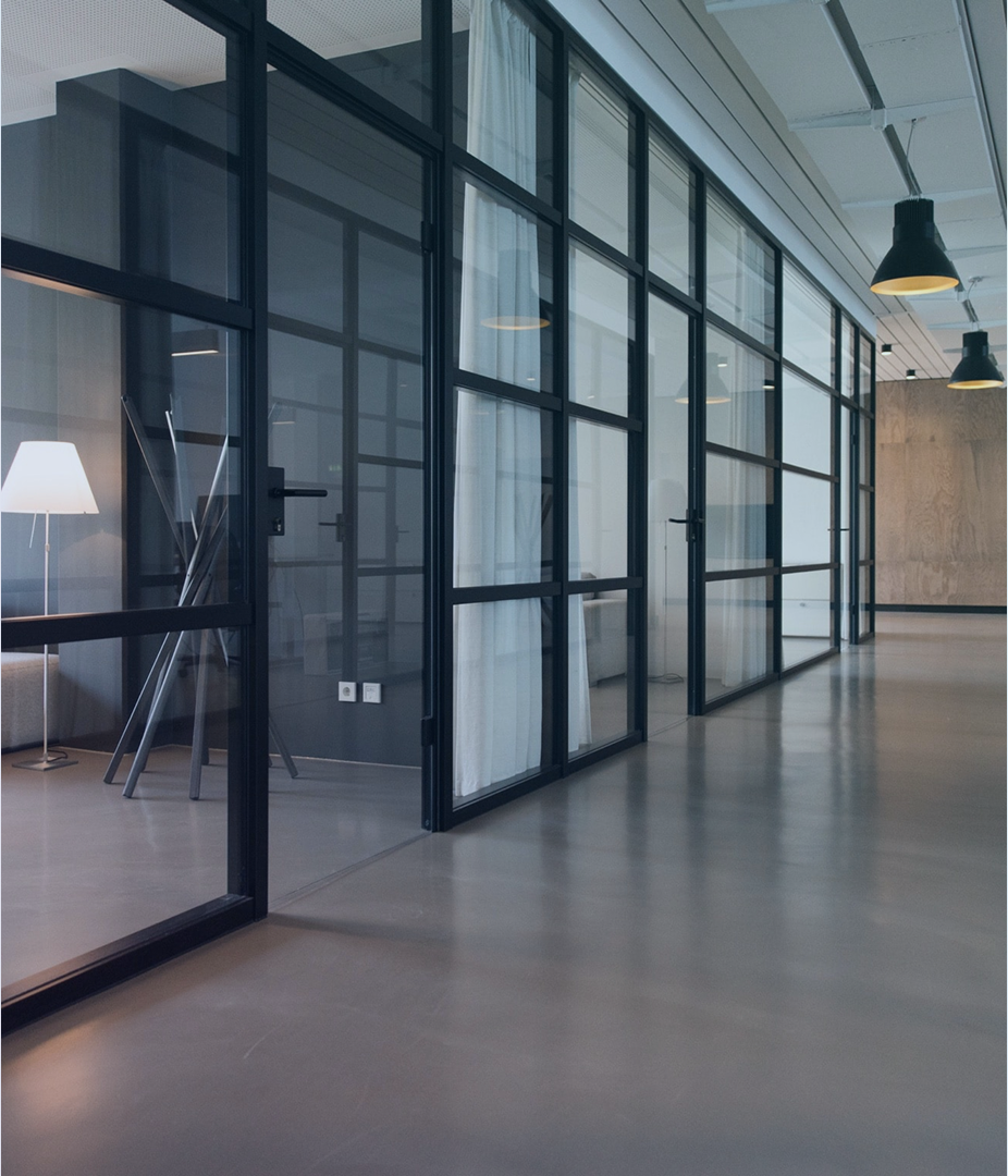 Modern office hallway with glass partitions.