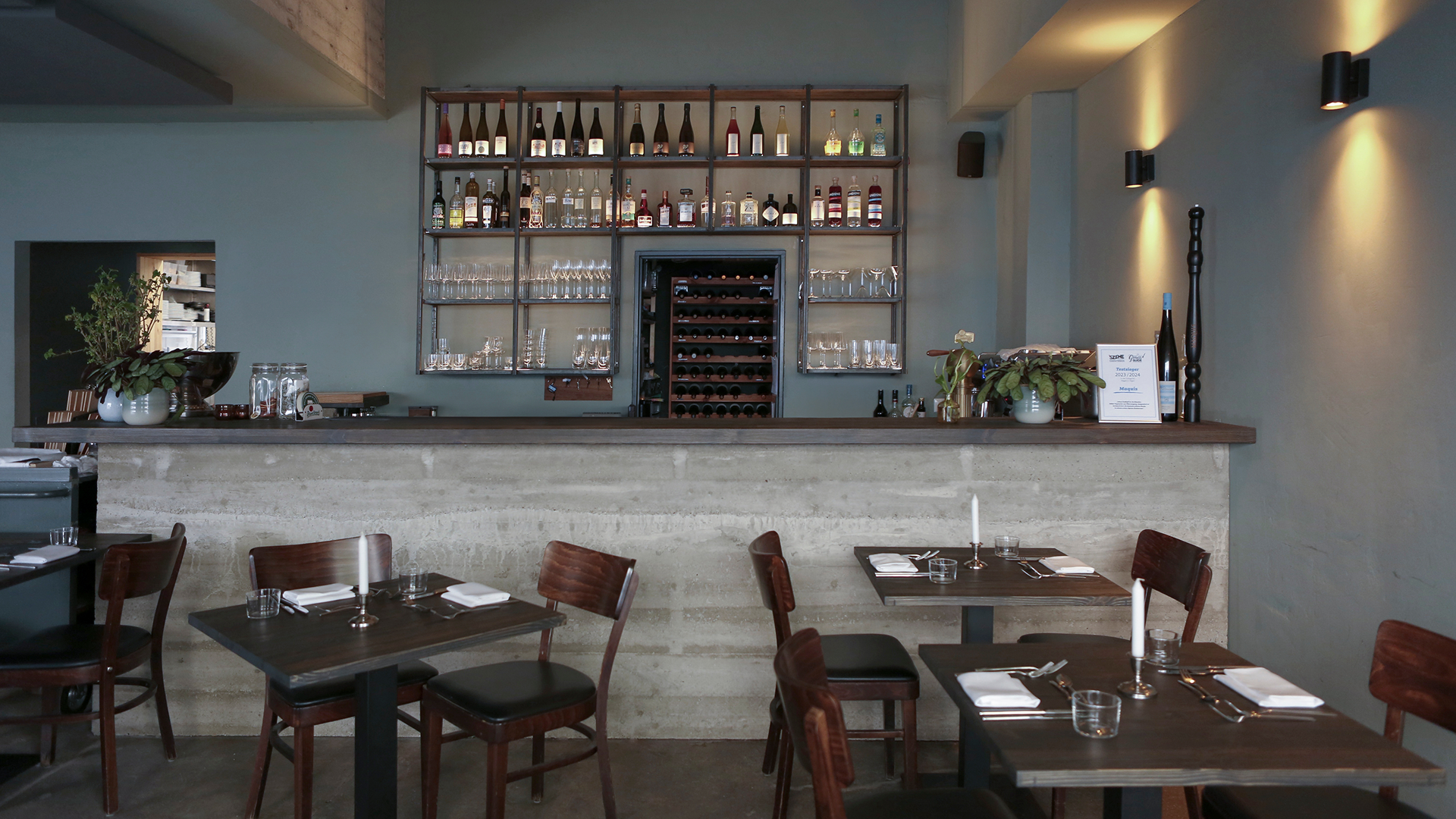 Modern restaurant interior with a bar and dining tables.