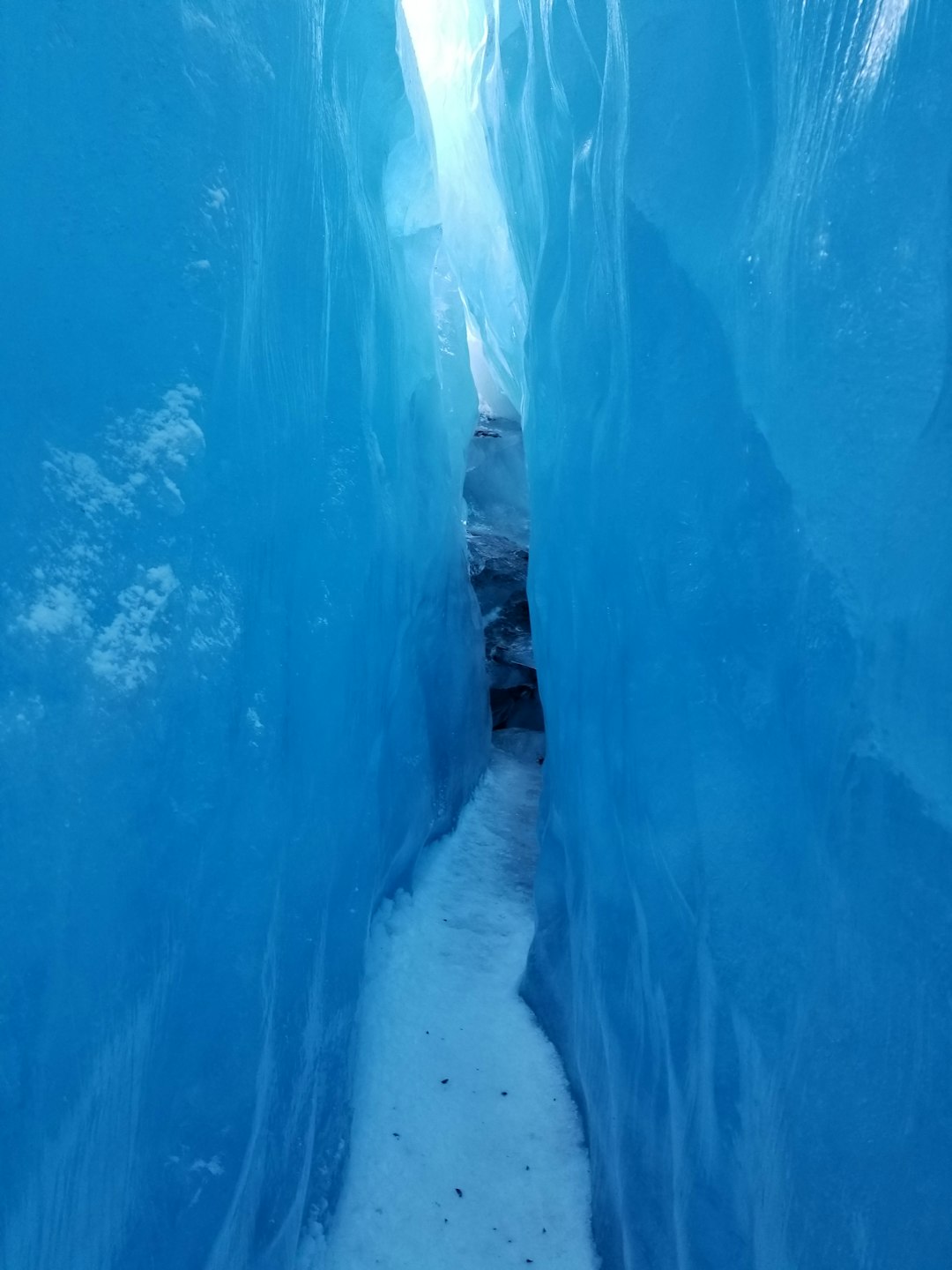 Narrow icy passage between blue glacier walls.