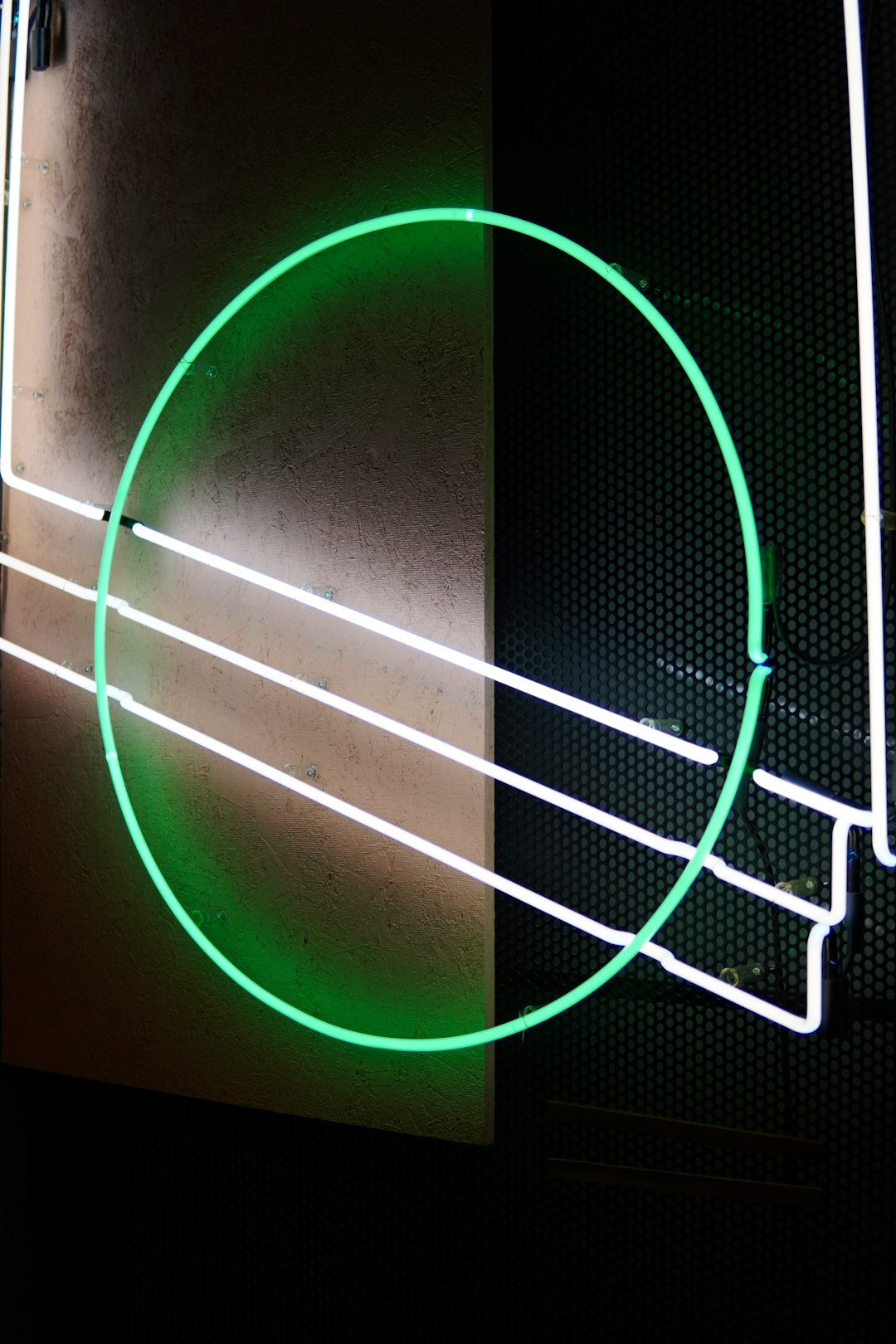 Neon green circle with white lines on a textured wall.