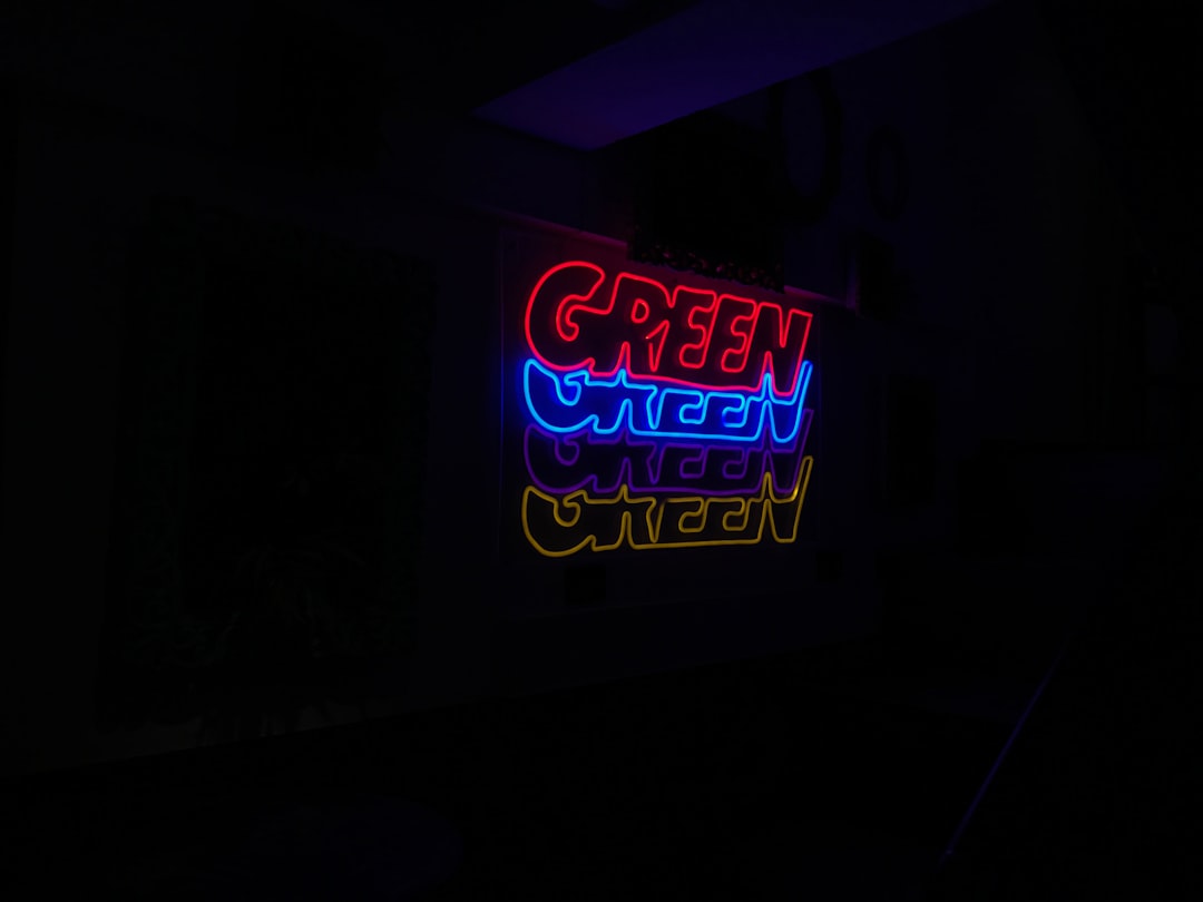Neon sign with the word 'GREEN' in multiple colors.