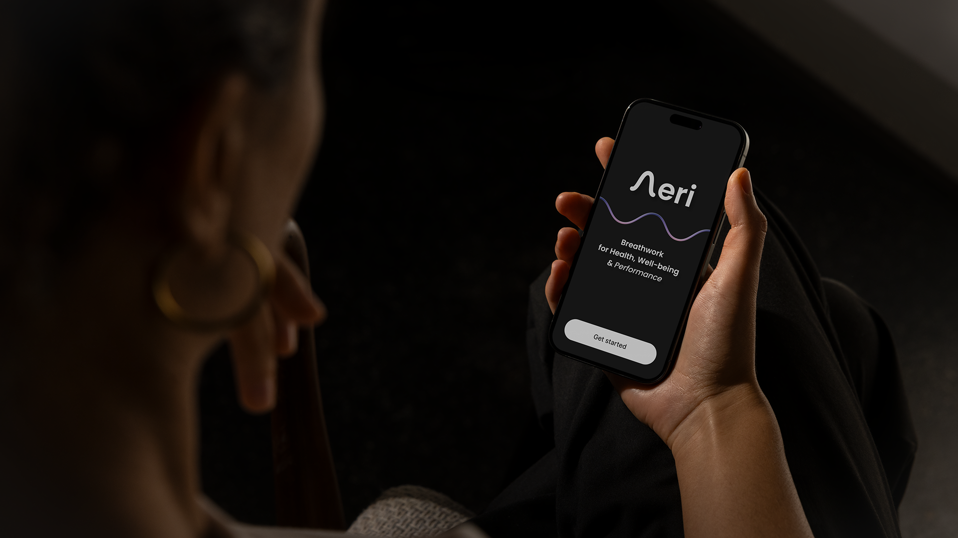 Person holding a smartphone displaying an app interface.
