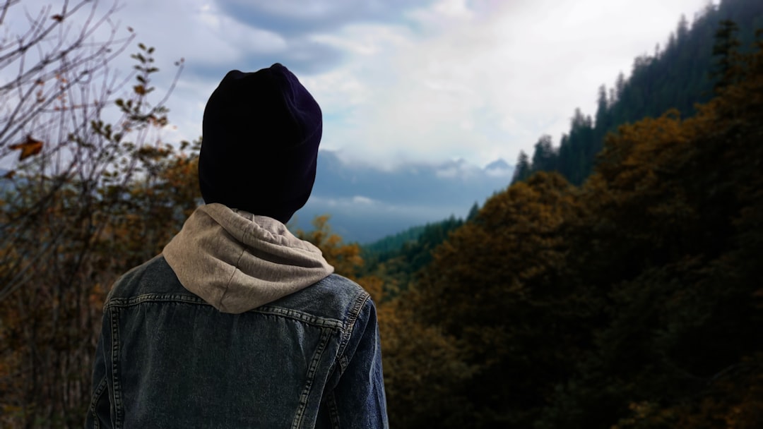 Person in a beanie looking at a mountain landscape.