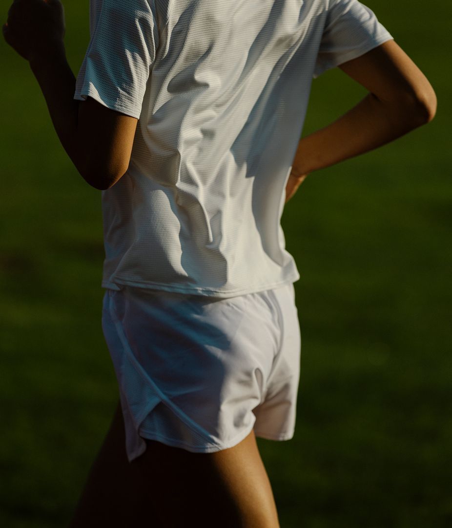 Person in athletic wear standing outdoors.