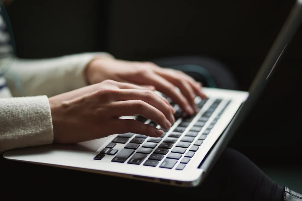 Personne tapant sur un clavier d'ordinateur portable.