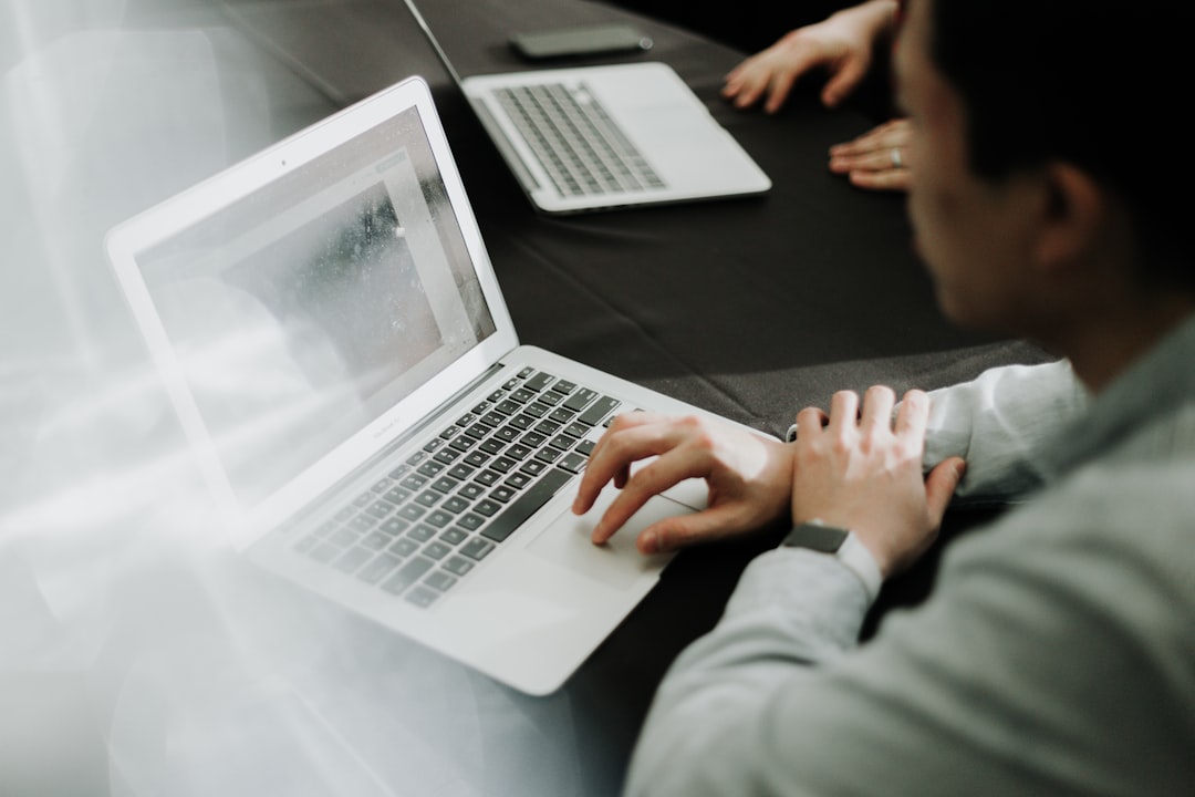 Person using a laptop at a table.