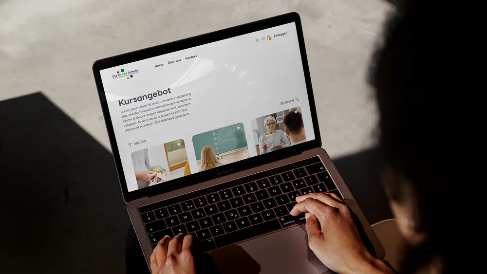 Person using a laptop displaying a website with educational content.