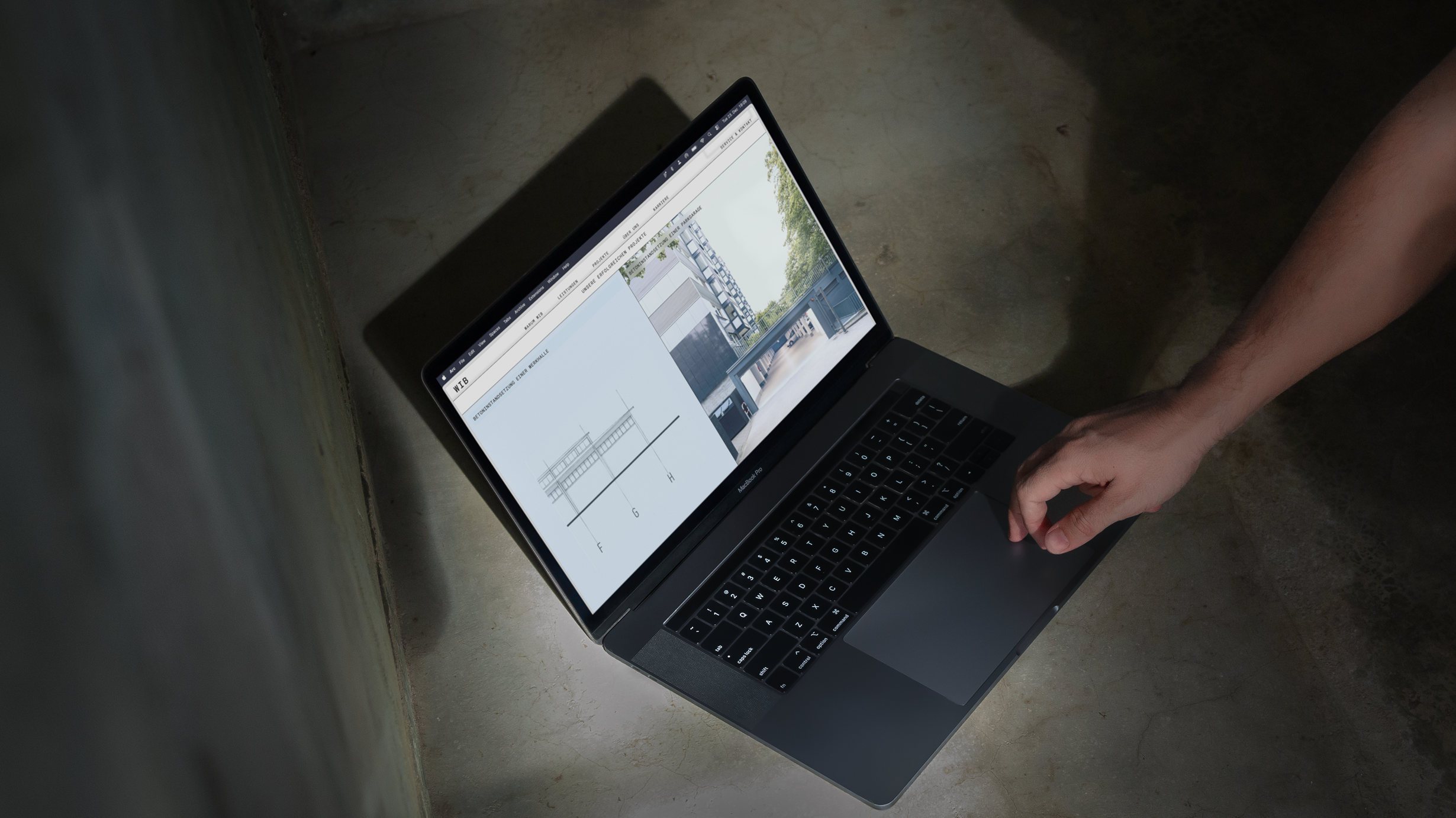 Person using a laptop on the floor.
