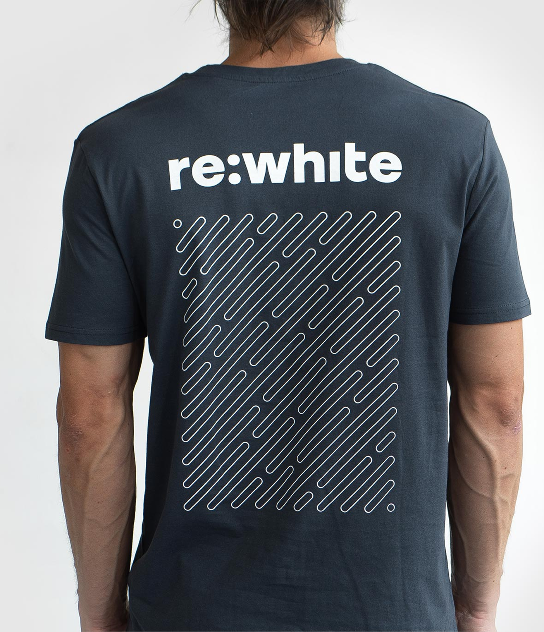 Person wearing a black t-shirt with 're:white' text and geometric design on the back.