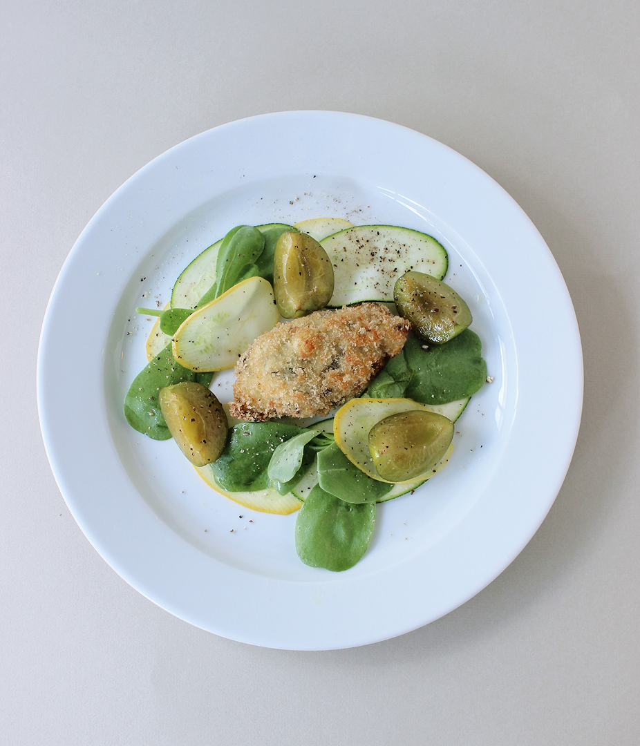 Plate of salad with breaded item and green vegetables.