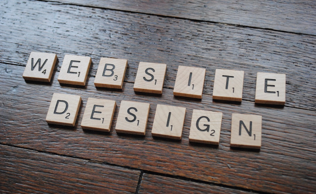 Scrabble tiles spelling 'WEBSITE DESIGN' on a wooden surface.