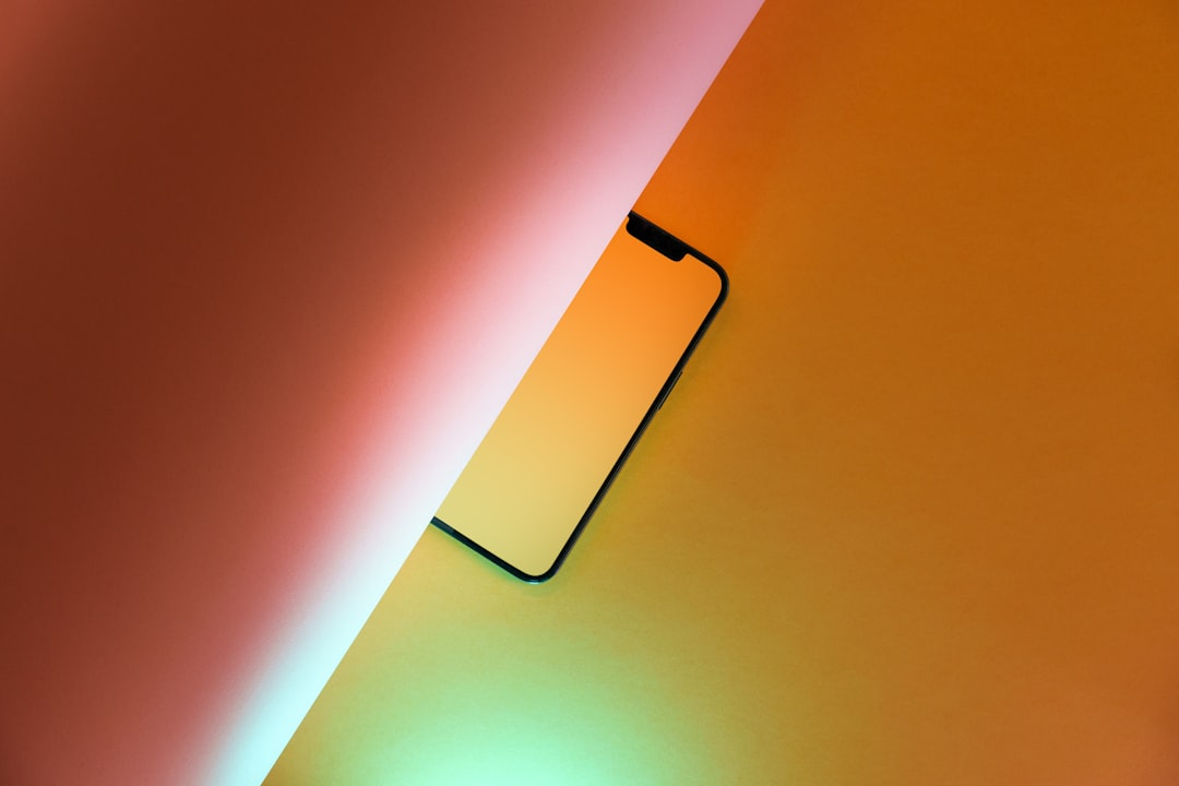 Smartphone partially covered by colorful paper.