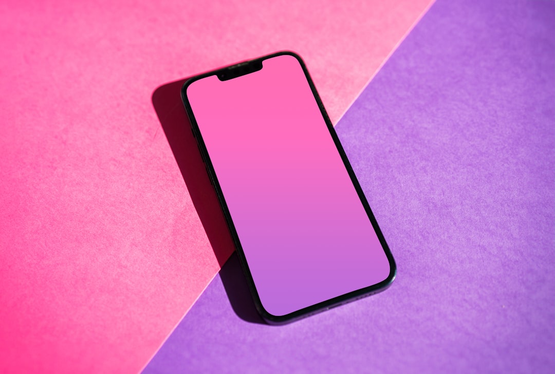 Smartphone with a pink gradient screen on a pink and purple background.