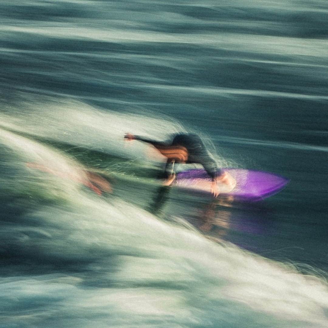Surfer riding a wave with motion blur.