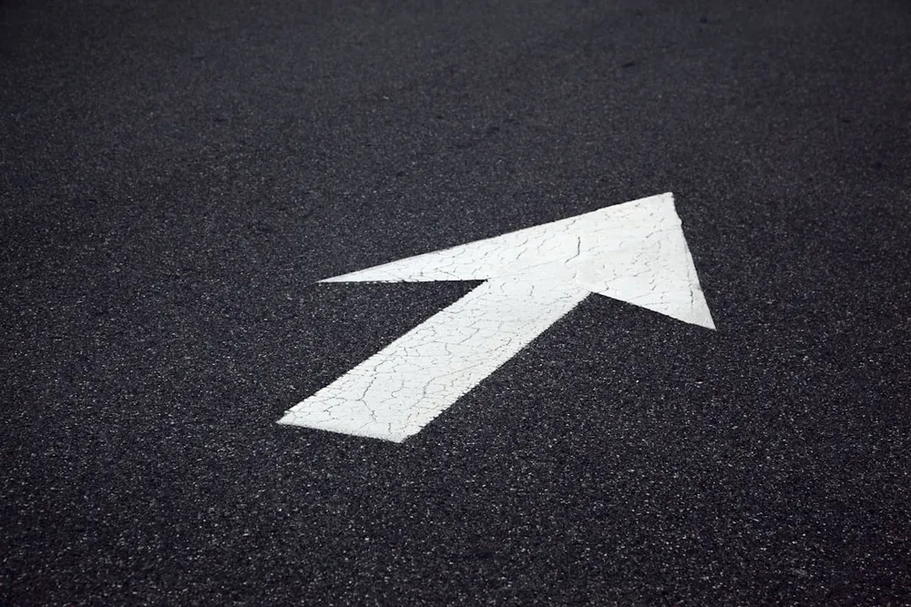 White arrow painted on asphalt pointing right.