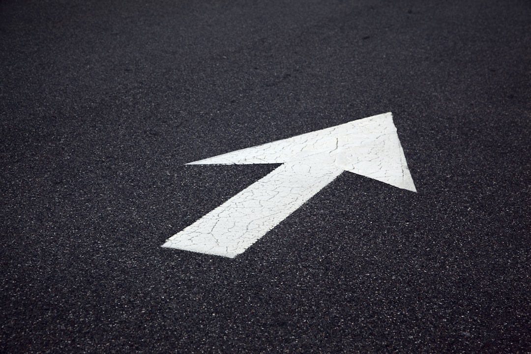 White arrow painted on asphalt pointing right.