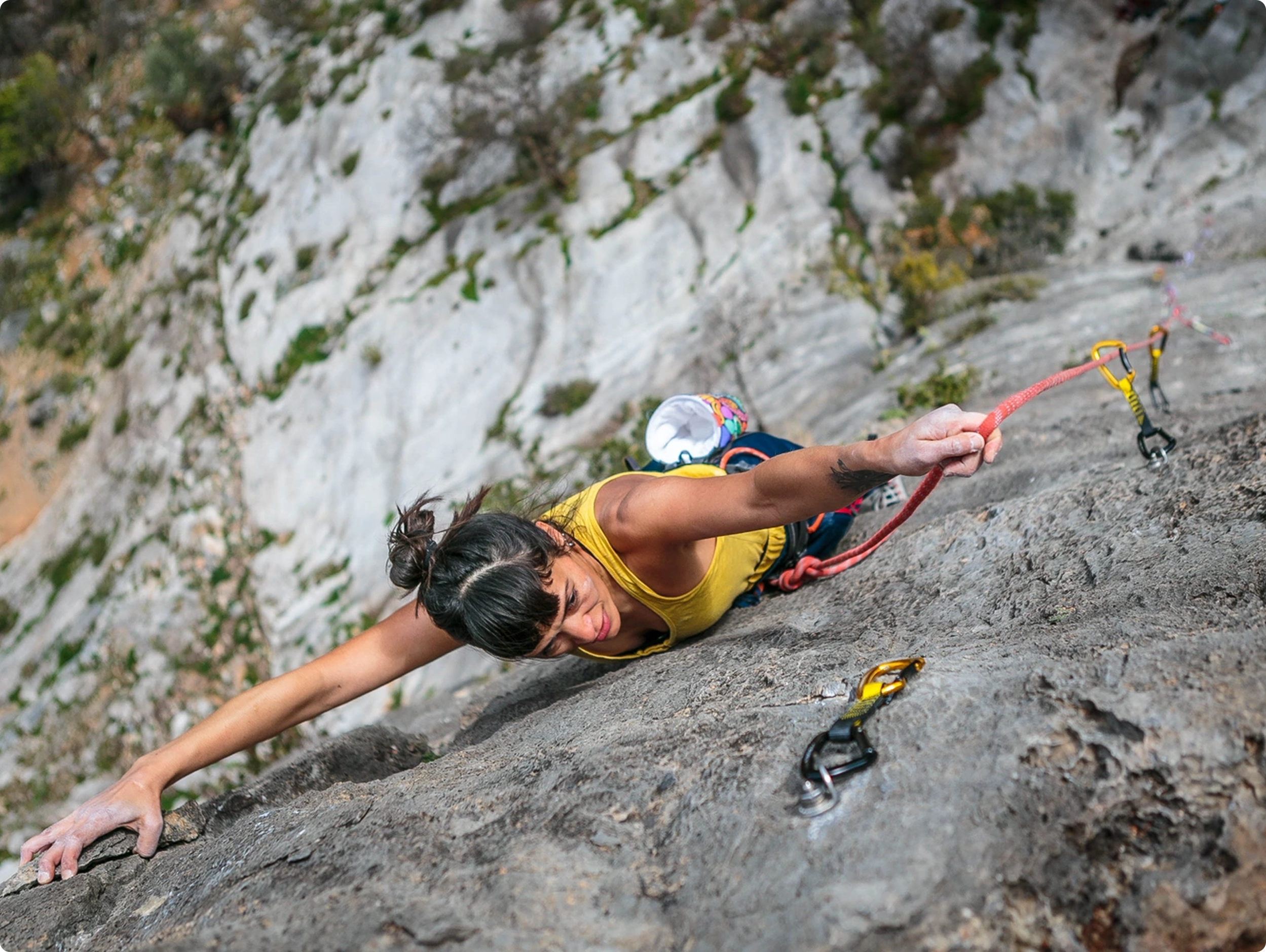 Woman rock climbing on a steep cliff.