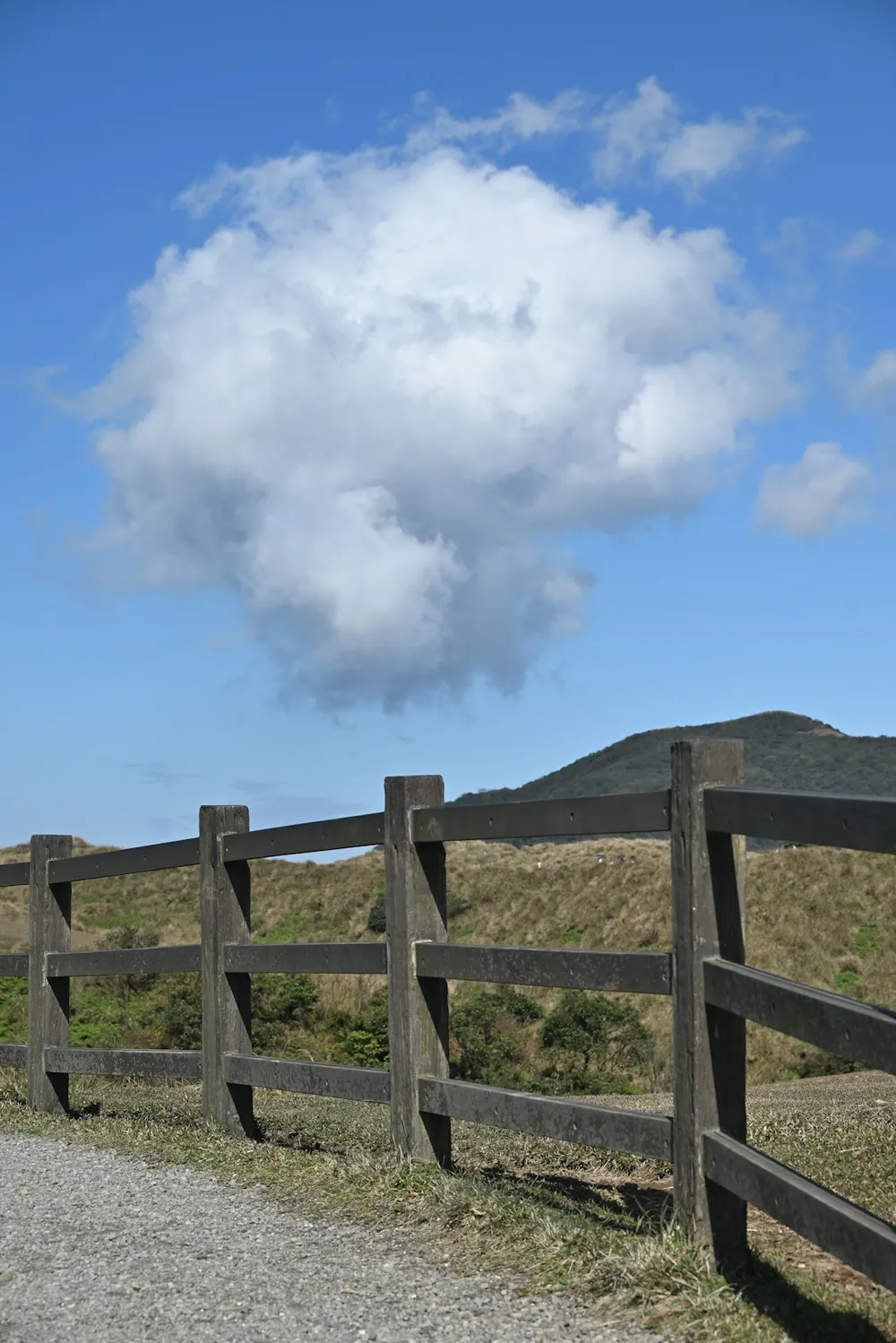 Træhegn med en stor sky på himlen.